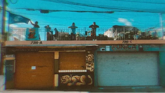 Devi Machete - Contra Viento Y Marea volunteers hang out on the rooftop of the space as they await the 2019 Pride Parade to march through their street. June 22, 2019. Tijuana, Mexico.