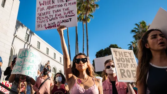 RAQUEL NATALICCHIO. A woman holds up a sign amongst a crowd of thousands of people that gathered in downtown Los Angeles to protest against the Supreme Court's decision to overturn Roe v. Wade.