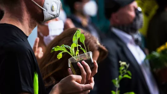 sam davis. Animal and climate justice protestors holding saplings in support of a plant-based food system whilst occupying Smithfield's Meat Market, London 2020