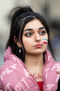 Fran hales. An Iranian girl has help painted over her mouth and the Iranian flag on her cheek, Trafalgar Square Sep 26